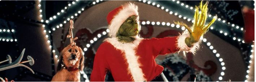 picture of the grinch and his dog max in whoville in front of lights